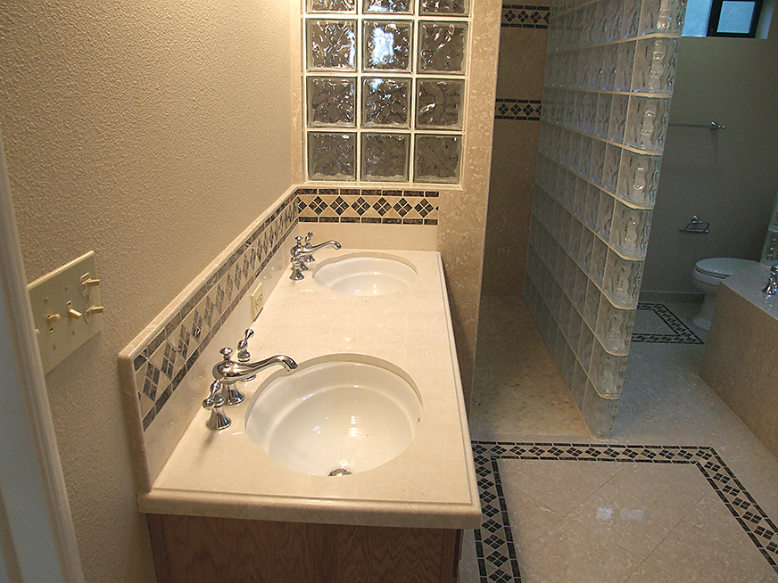 Stone tiling, glass block shower wall, marble floor tiling and engineered stone counter tops.