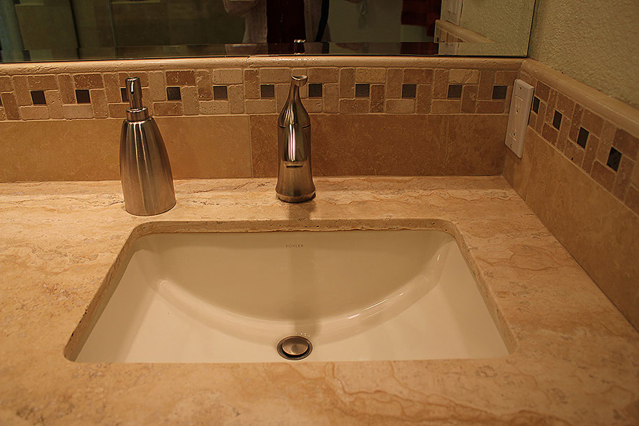 Marble bathroom countertop, stone tile backsplash.