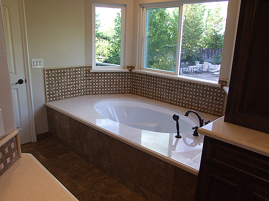 Engineered stone bathtub installation, stone countertops and floor tiles.