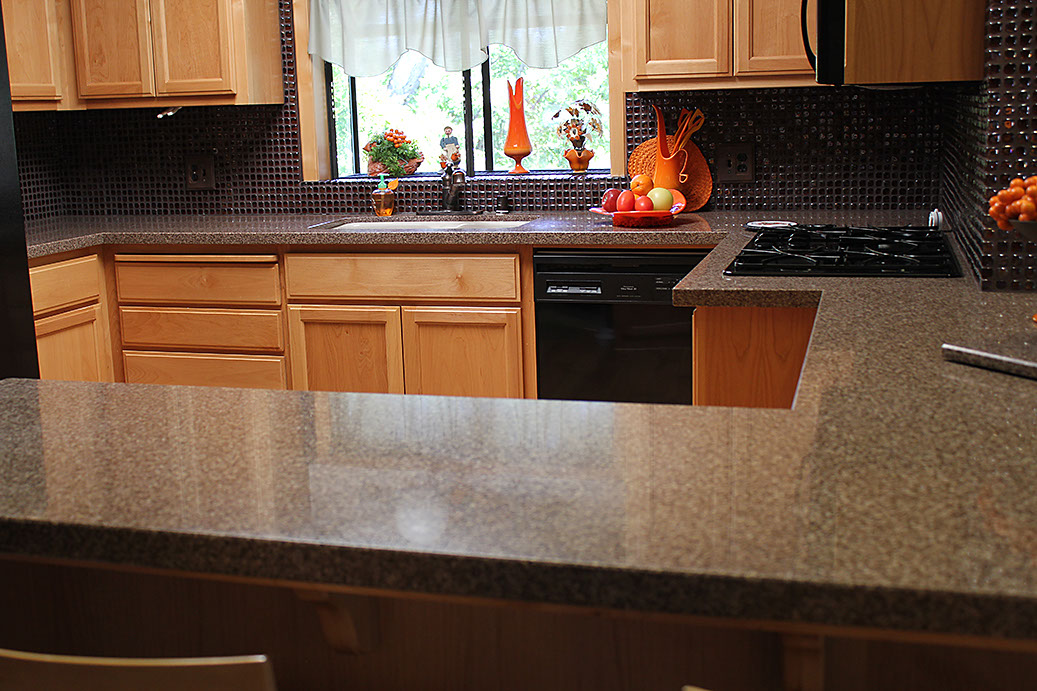 Beautiful granite countertops in kitchen. Glass tile backsplash on wall.