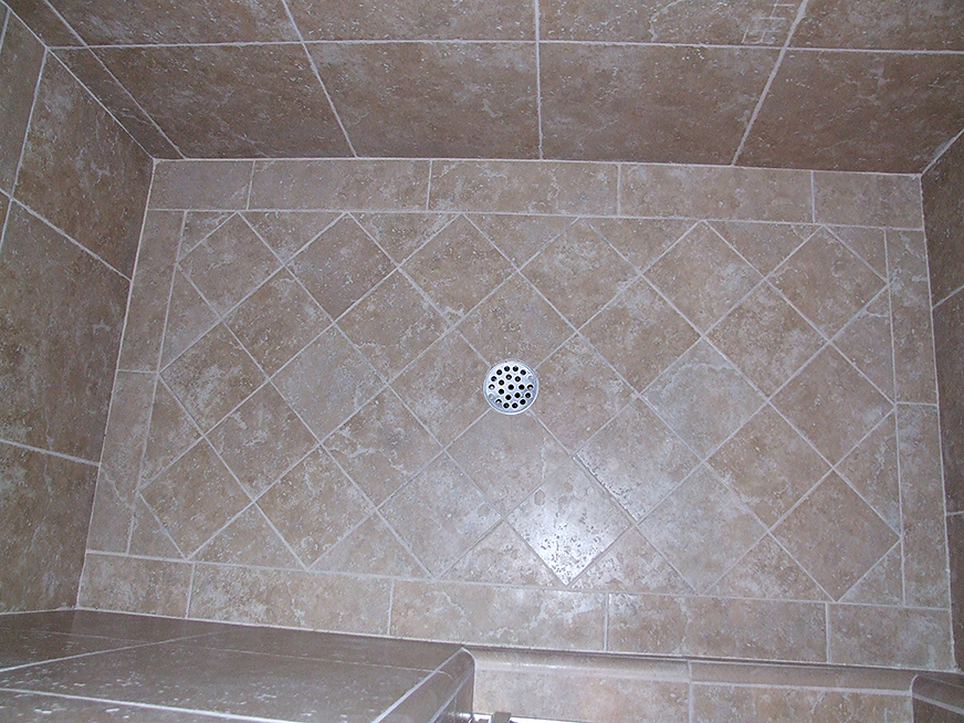 Stone tiling in shower stall floor and walls.
