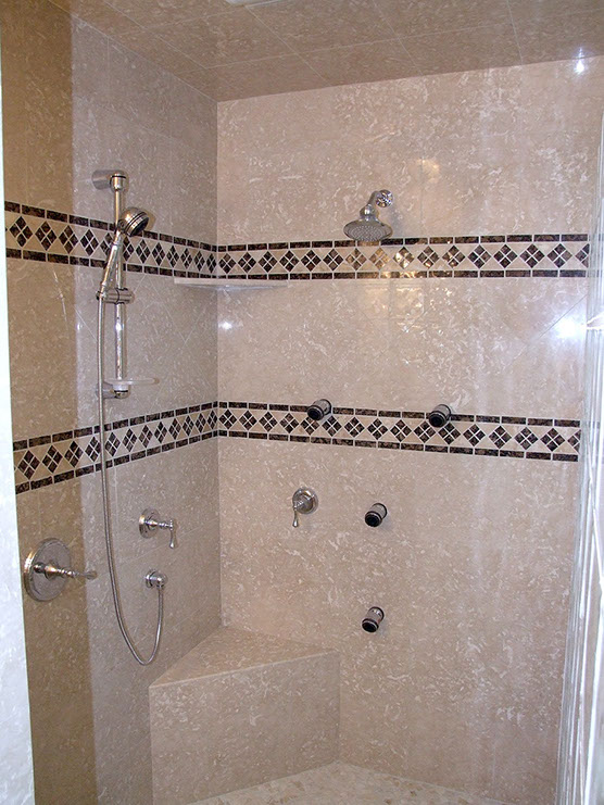 Marble tiling of shower stall with intricate tile inserts.